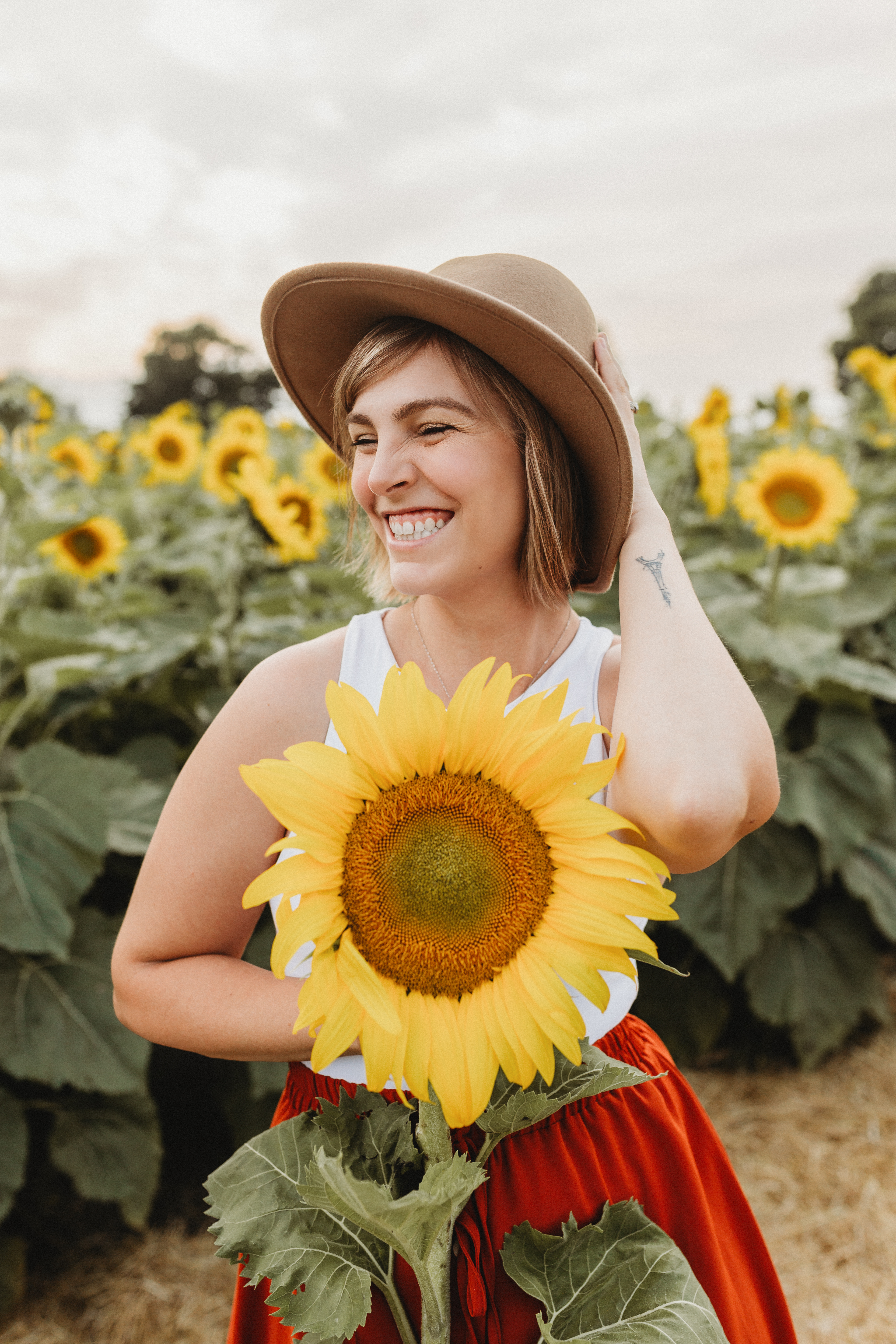 Guest holding a sunflower in the fields at EkkoFarm organic farm near Valencia